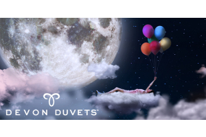 A dreamy night-time scene featuring a person floating on a fluffy cloud, holding colourful balloons, with a large glowing moon in the background and the Devon Duvets logo displayed below.