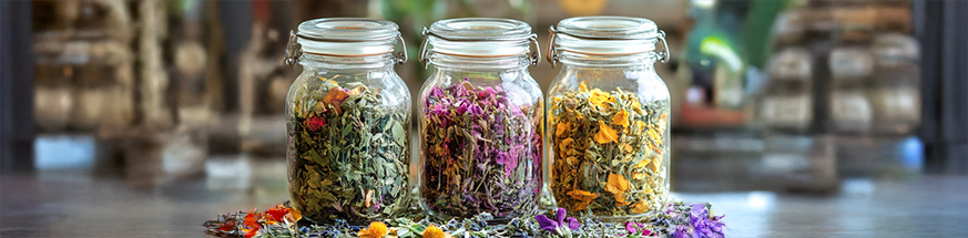 Assorted dried herbal teas neatly arranged in clear glass jars, ready for gifting.