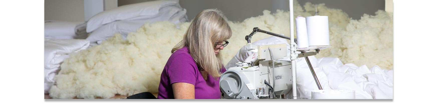 Seamstress working in a well-equipped workshop surrounded by ethically sourced wool.